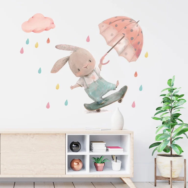 SIPO wall decoration for a child's room: a bunny riding a skateboard under a pink umbrella and pastel rain, with a pink cloud above it.