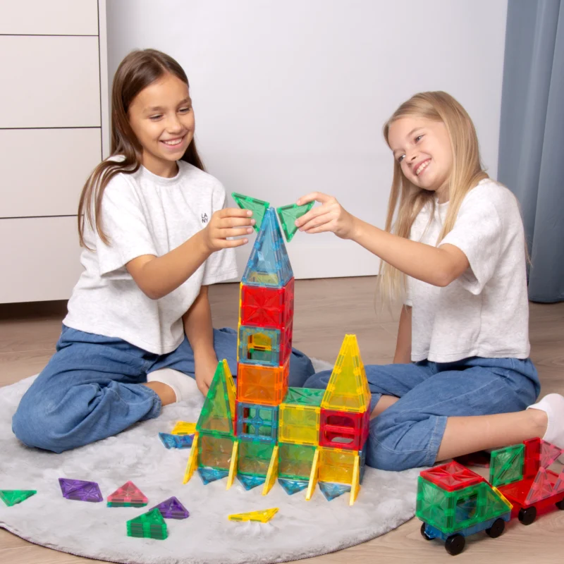 Dwoje dzieci wspólnie buduje kolorowy zamek z klocków magnetycznych SIPO Wonder Kingdom.